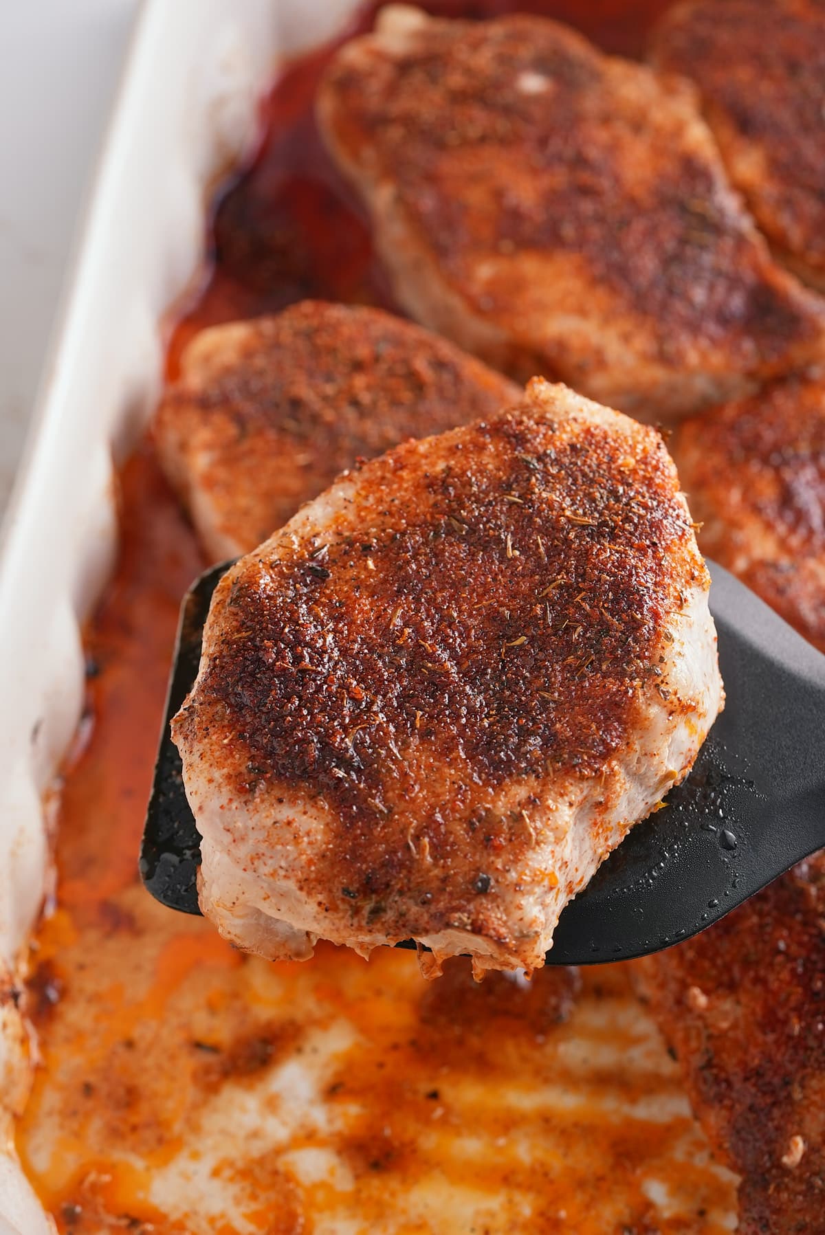 Oven baked pork chop on a spatula.