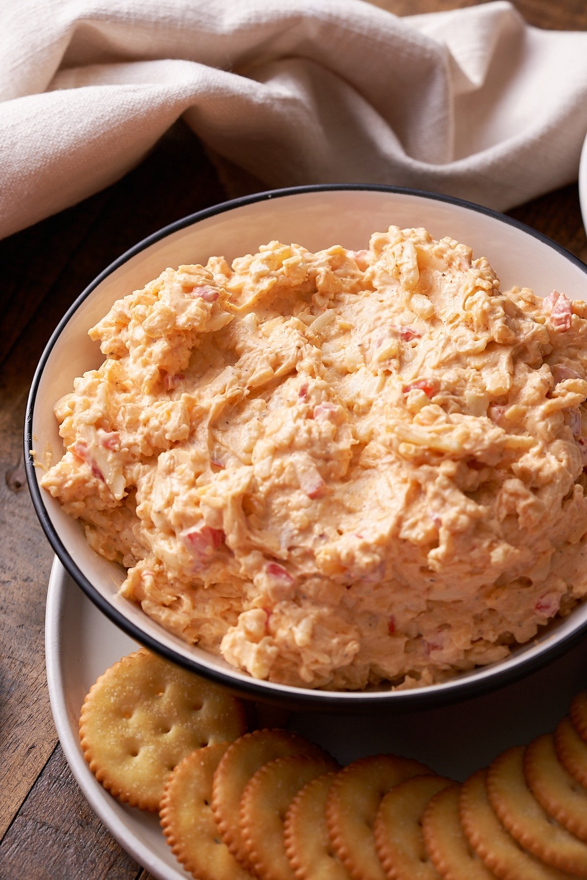 Pimento cheese served in a bowl next to crackers.