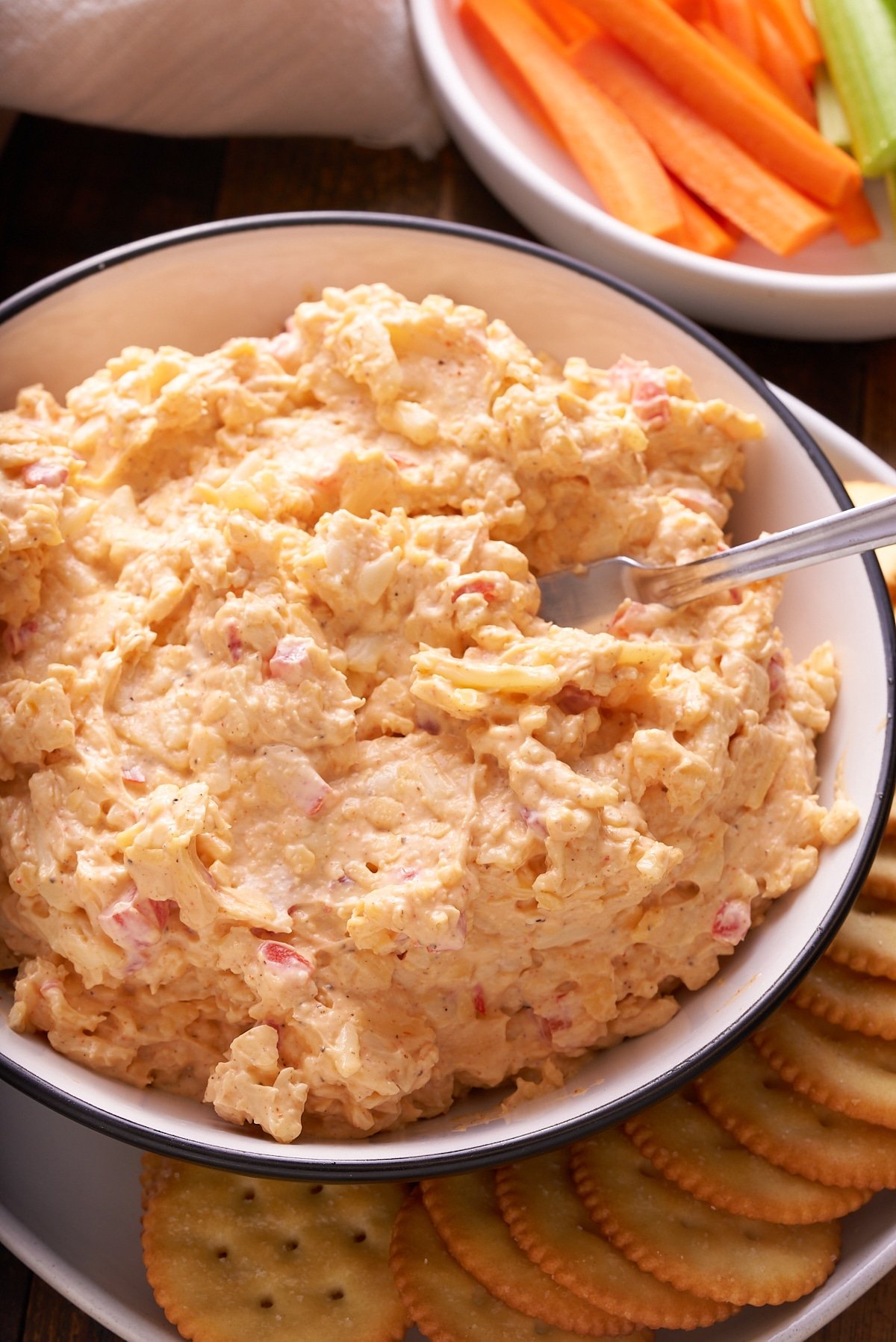 Pimento cheese served in a bowl next to crackers.