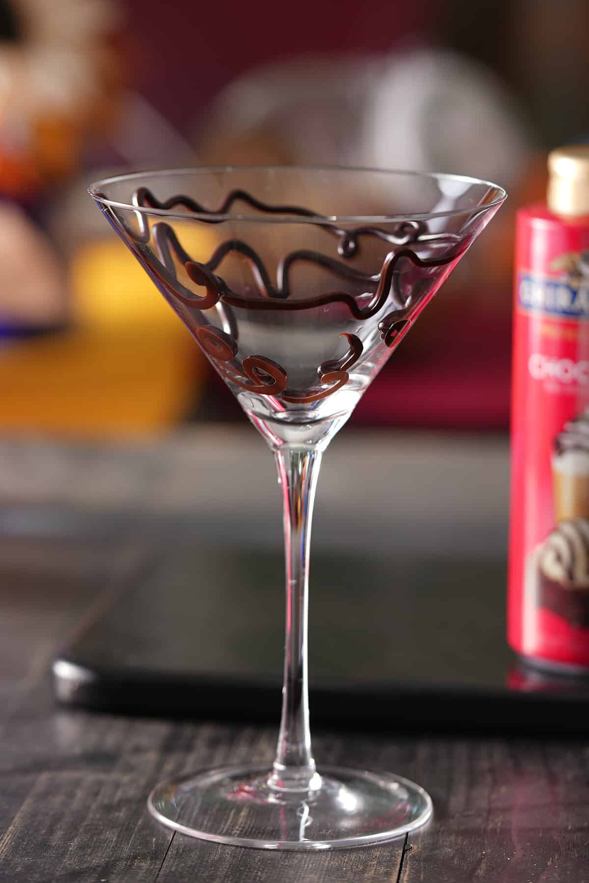 martini glass garnished with chocolate syrup.