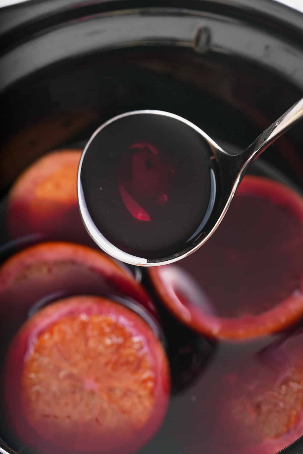 A ladle filled with mulled red wine.