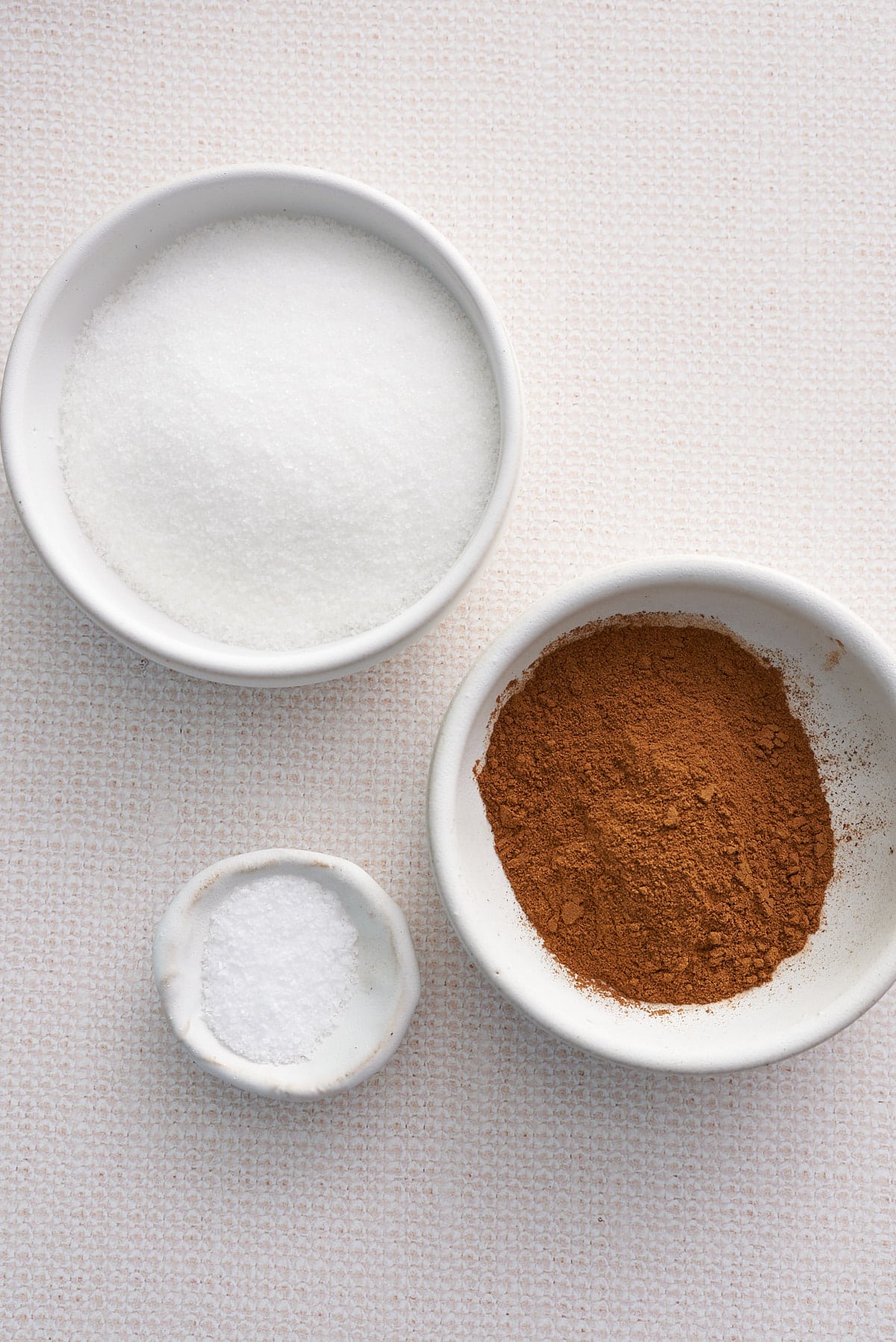 Cinnamon sugar recipe ingredients set out in individual bowls.