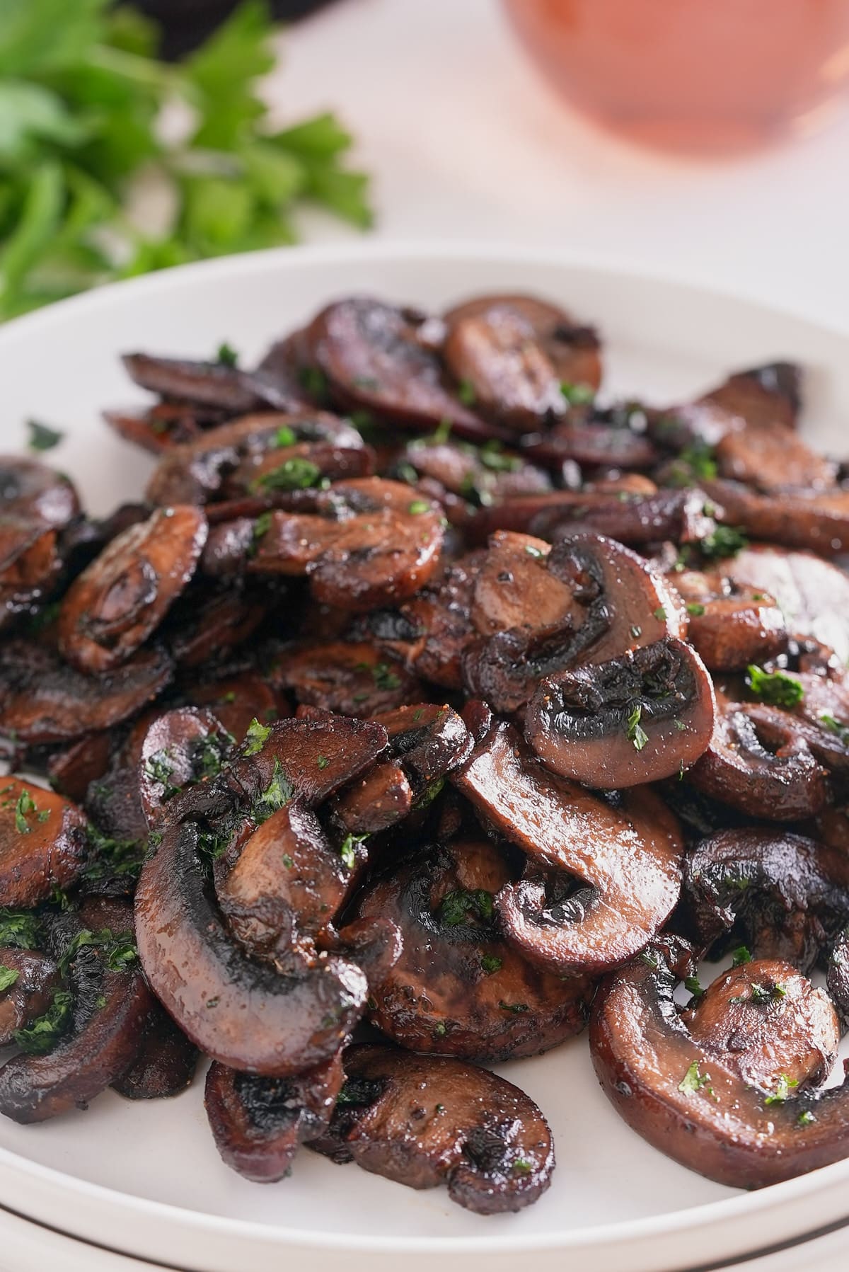 A white plate piled high with sauteed mushrooms.