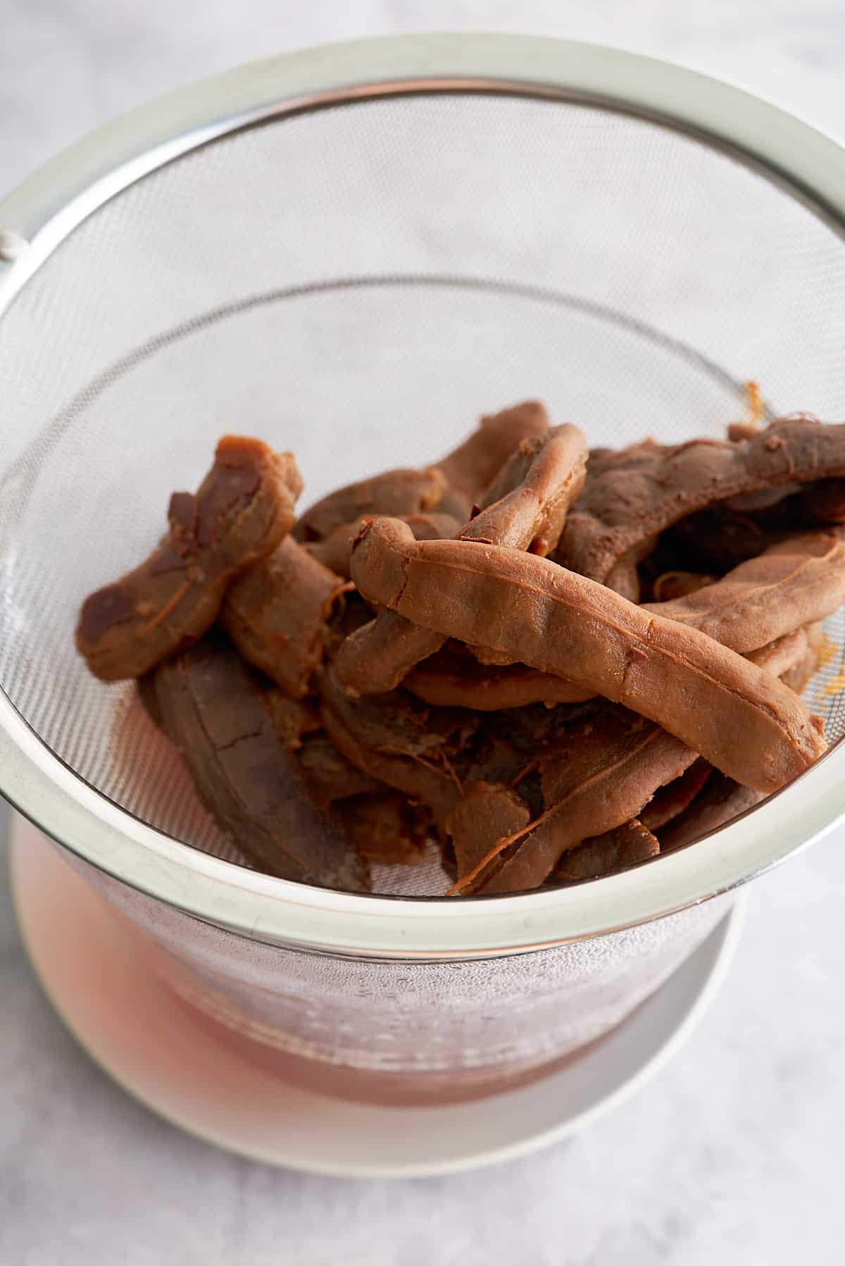 A sieve of cooked tamarind pods.