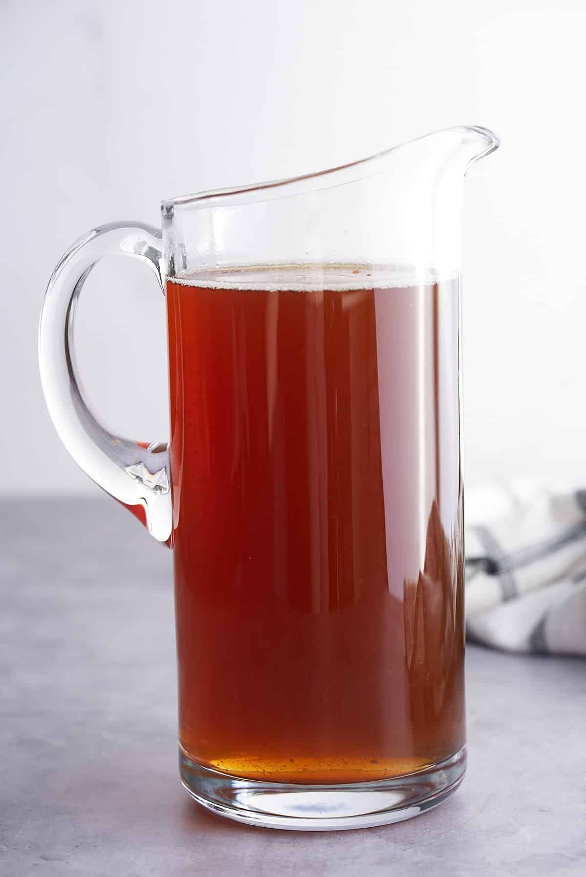 A large glass pitcher filled with tamarind juice.