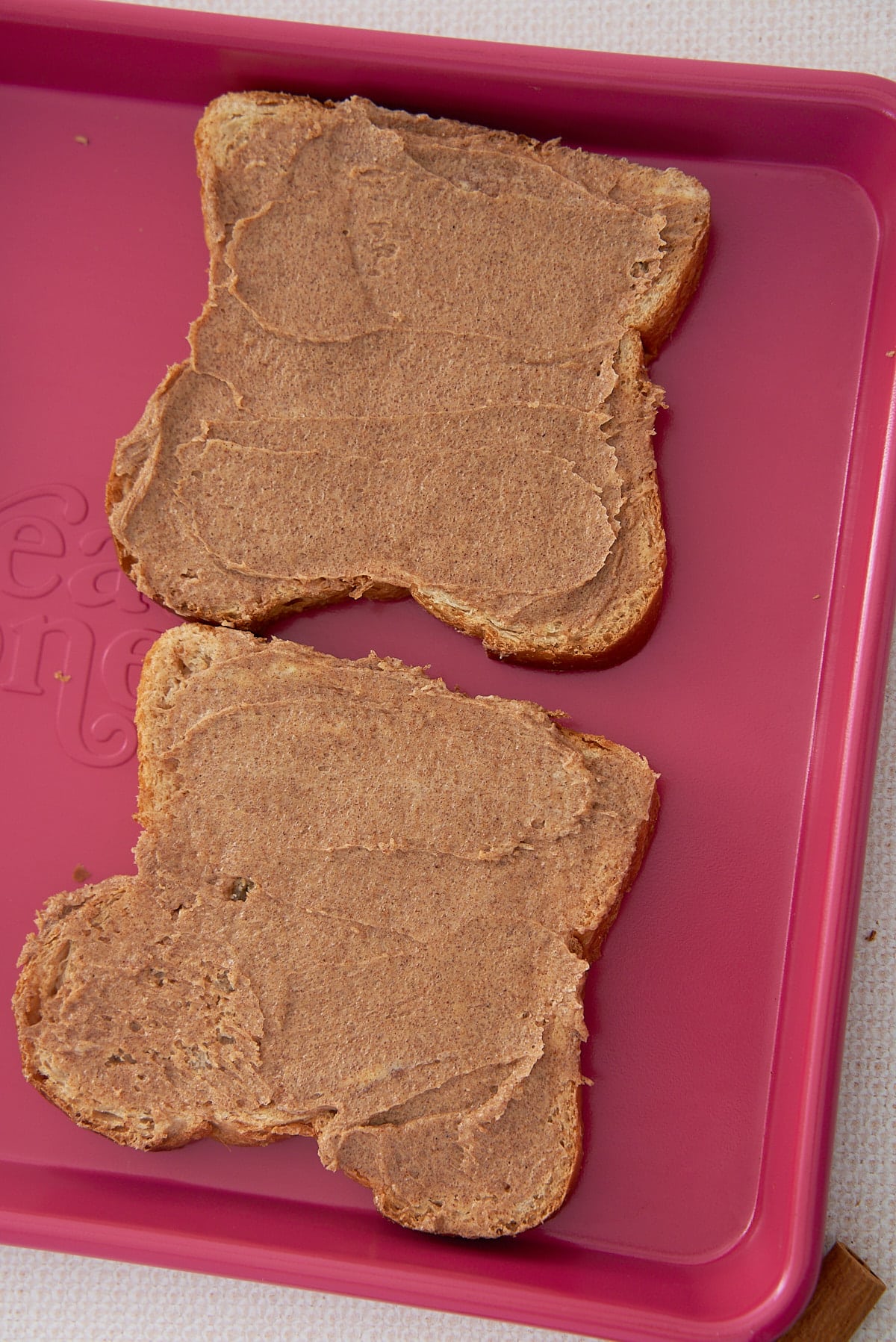 A tray with 2 slices of whole wheat bread topped with cinnamon sugar butter.