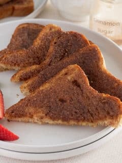 A white plate of sliced cinnamon toast.