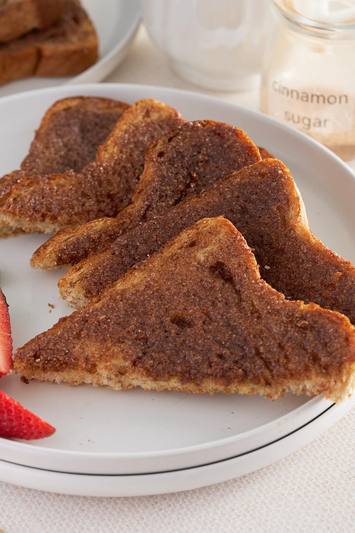 A white plate of sliced cinnamon toast.