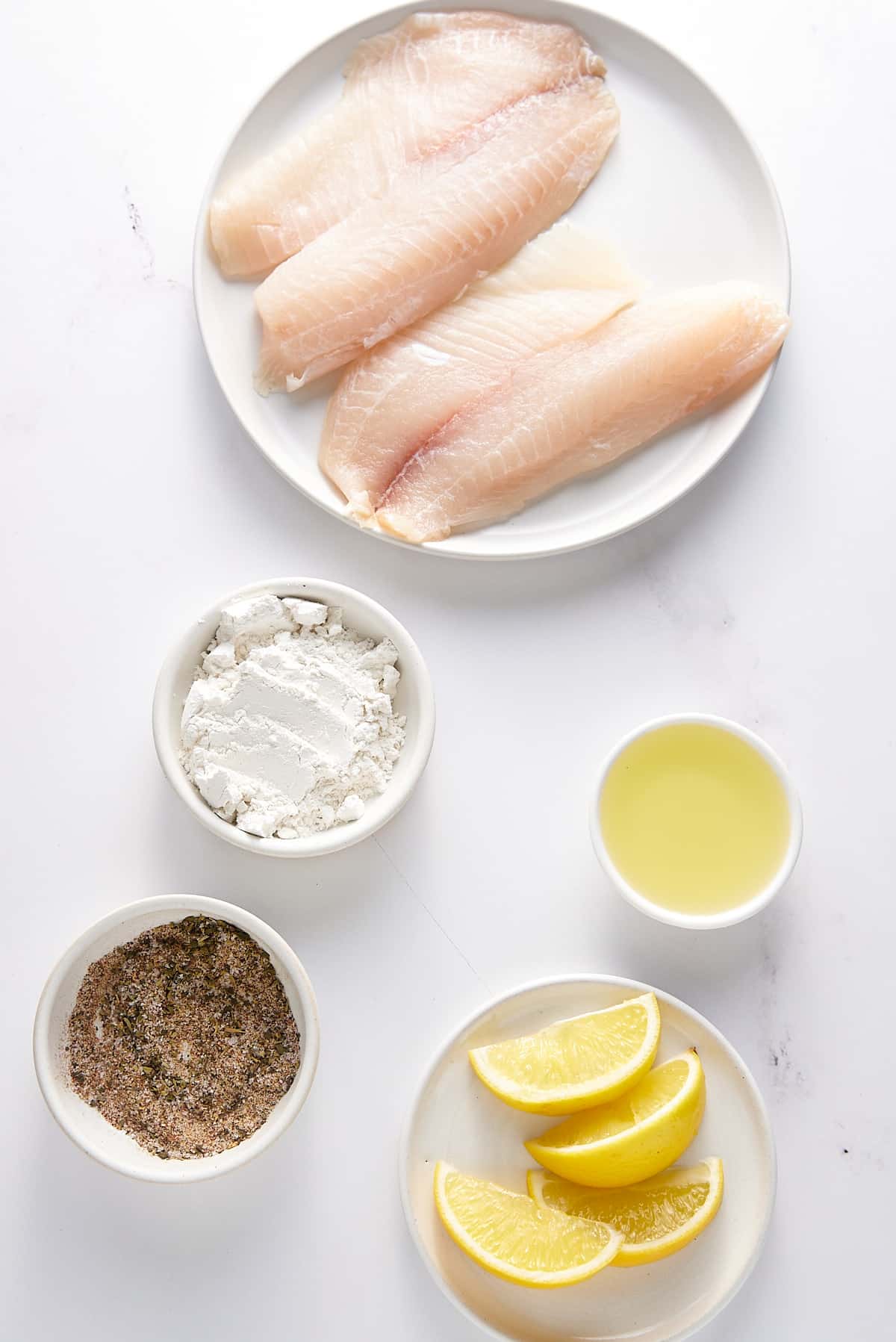 Pan fried fish recipe ingredients set out in individual bowls.