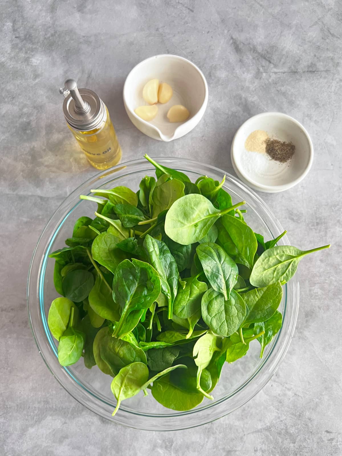 ingredients for sauteed spinach, spinach, olive oil, garlic cloves, salt, pepper, onion powder