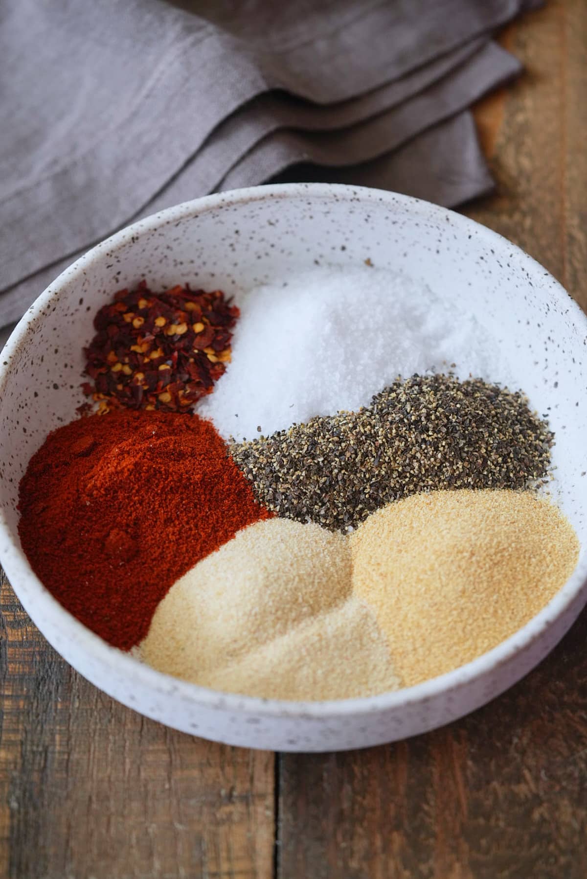 A bowl filled with ingredients for steak seasoning.