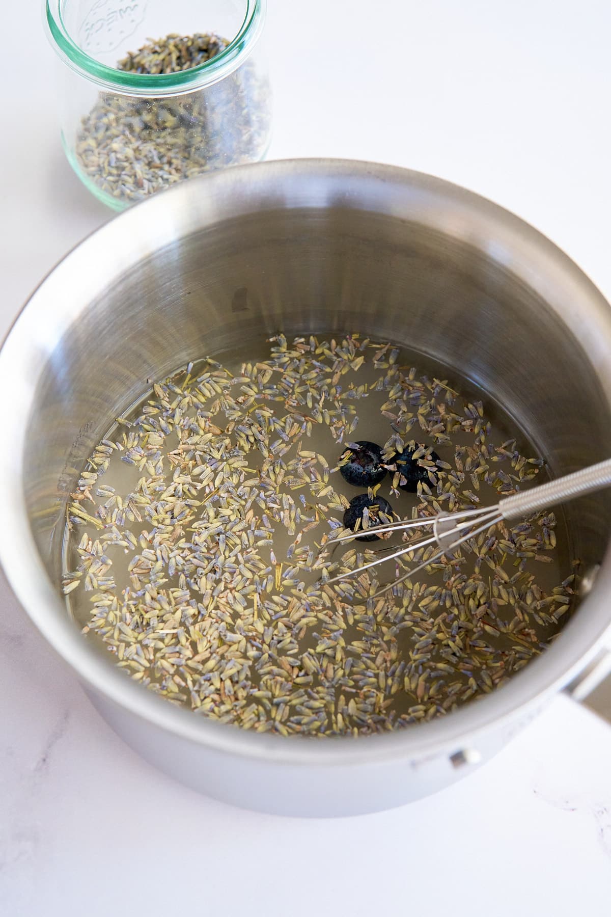 lavender simple syrup ingredients in saucepan before simmering