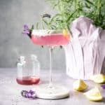lavender martini in glass in front of lavender plant