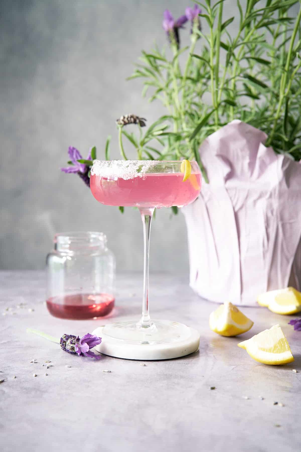 lavender martini in glass in front of lavender plant