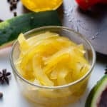 pickled watermelon rind in glass container with watermelon peel on side