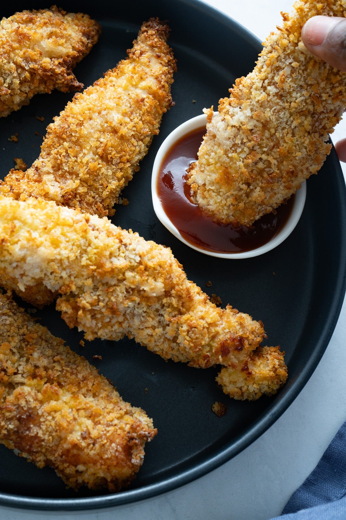 chicken tender being dipped in sauce