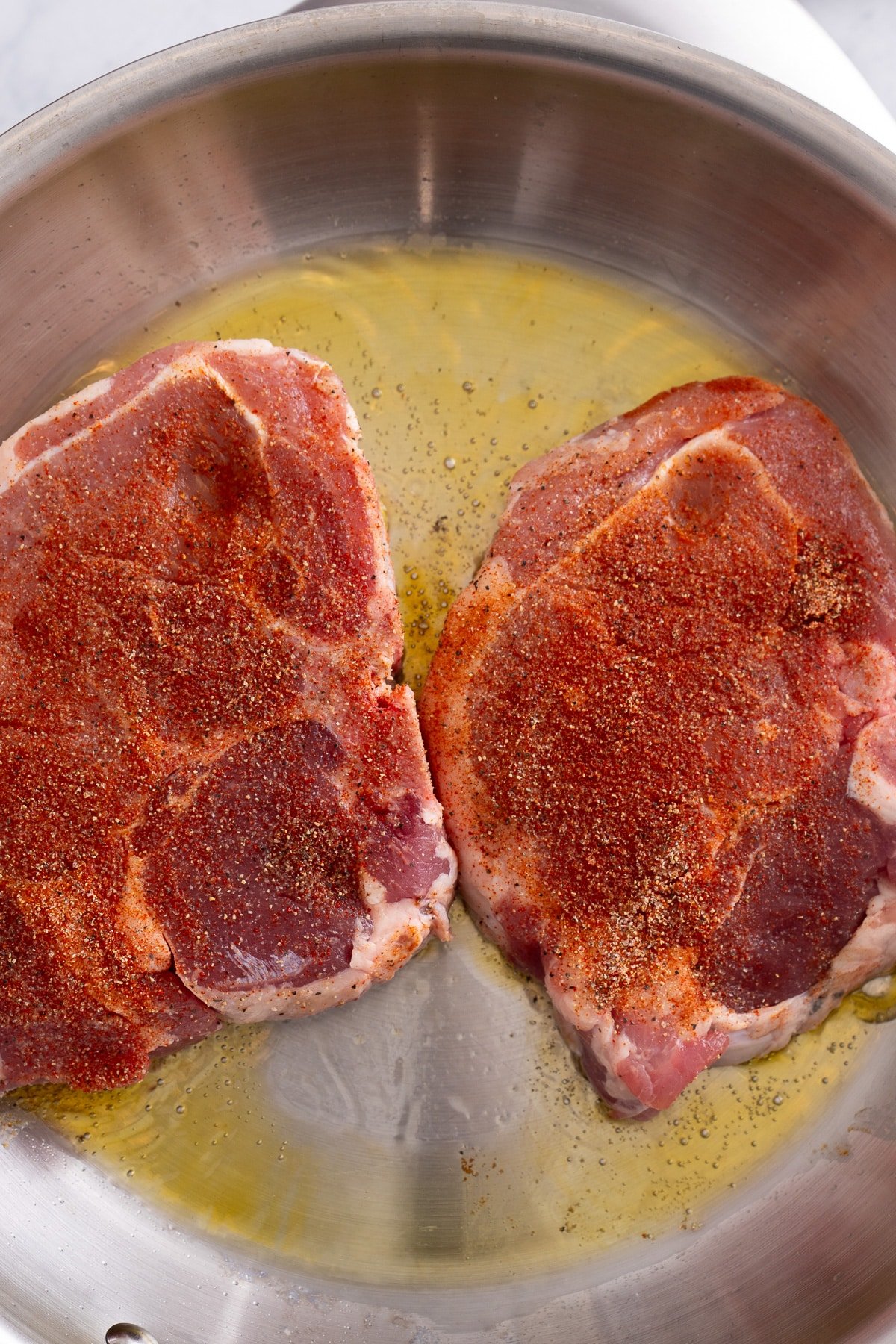 raw pork chops in skillet