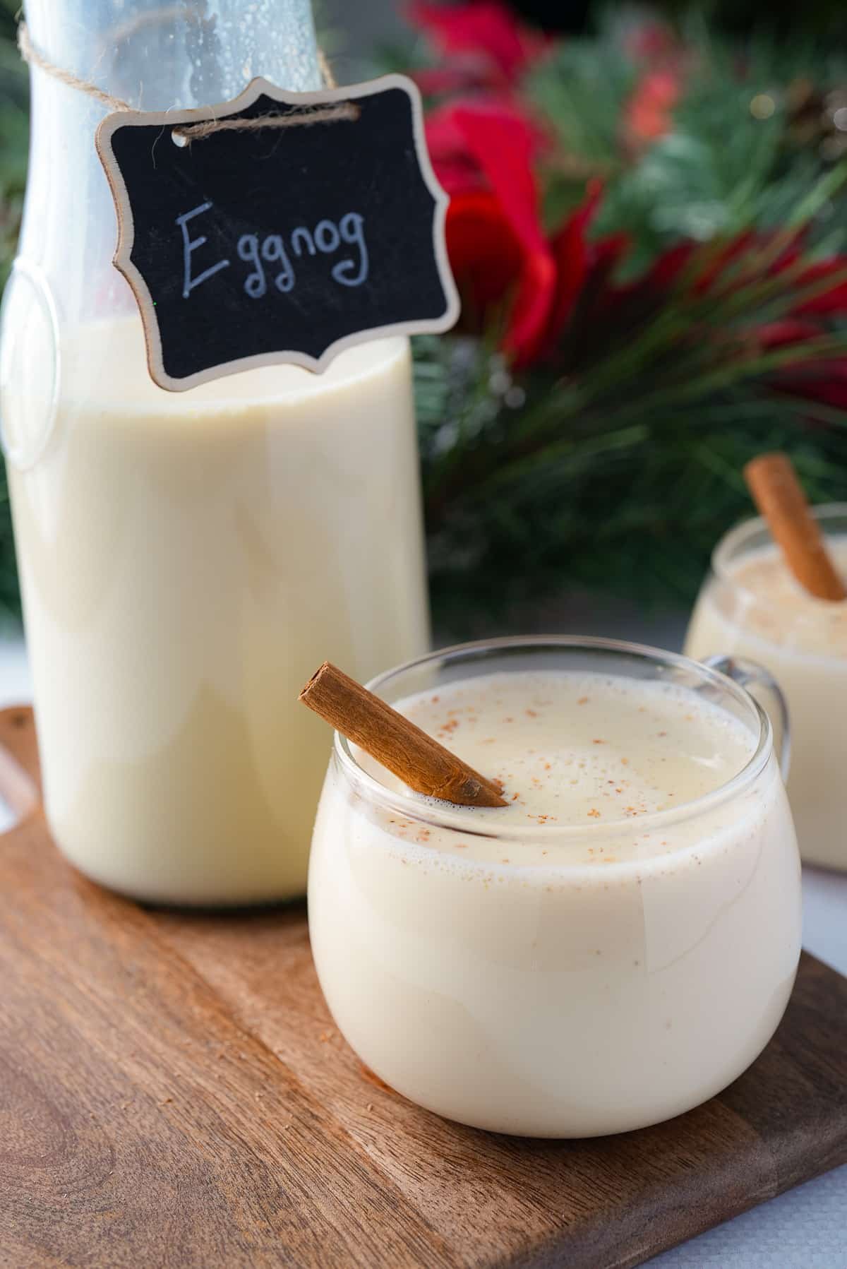 eggnog in glass with jar of eggnog with sign that says eggnog