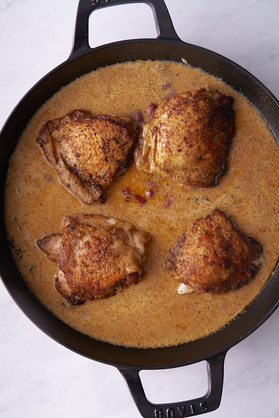 chicken thighs sitting on top of liquid and rice