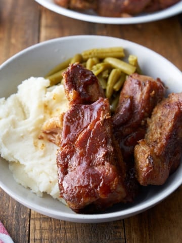 country style ribs on plate with mashed potatoes and green beans