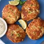 crab cakes on plate with lemon on side