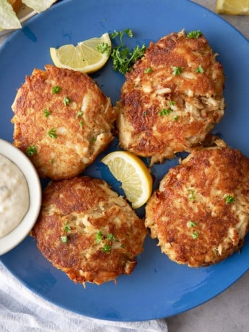 crab cakes on plate with lemon on side