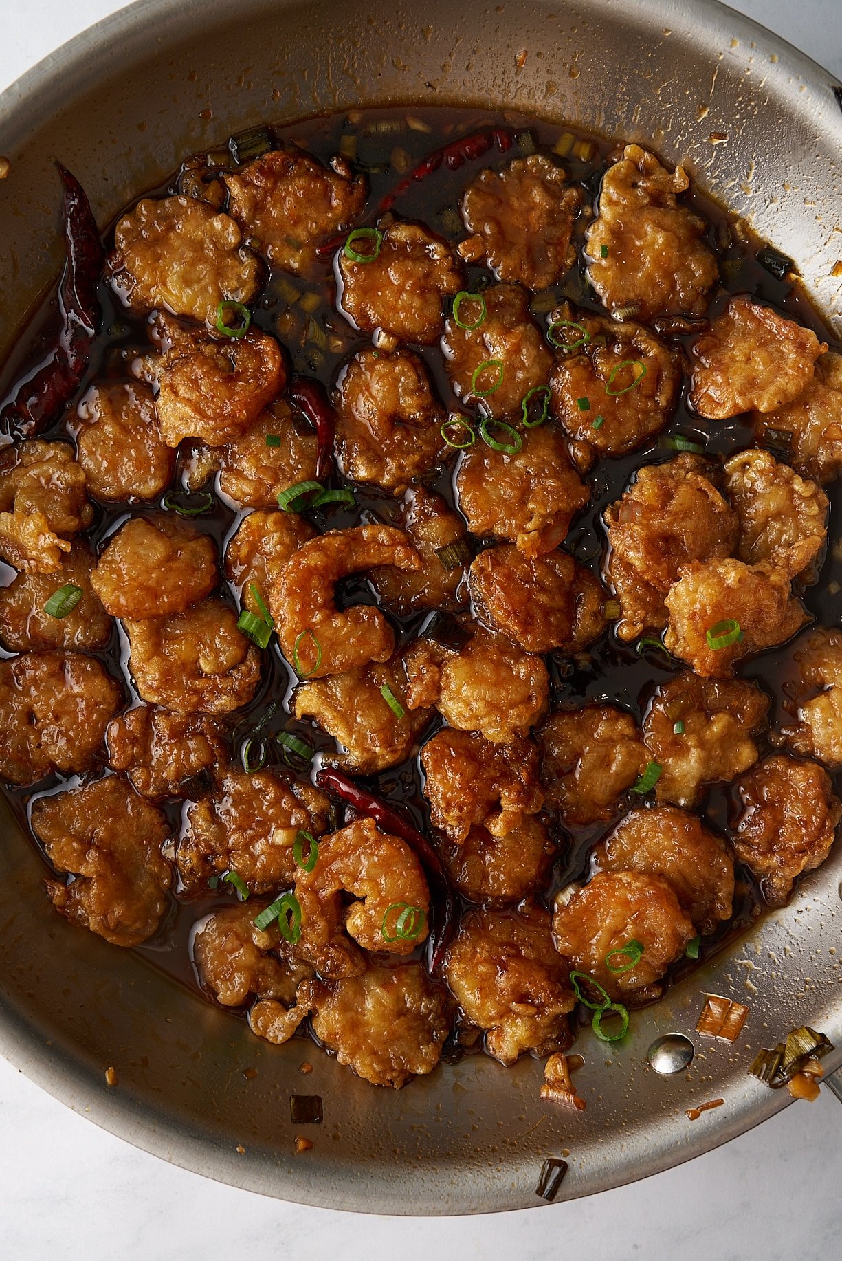general tso shrimp in sauce garnished with green onions