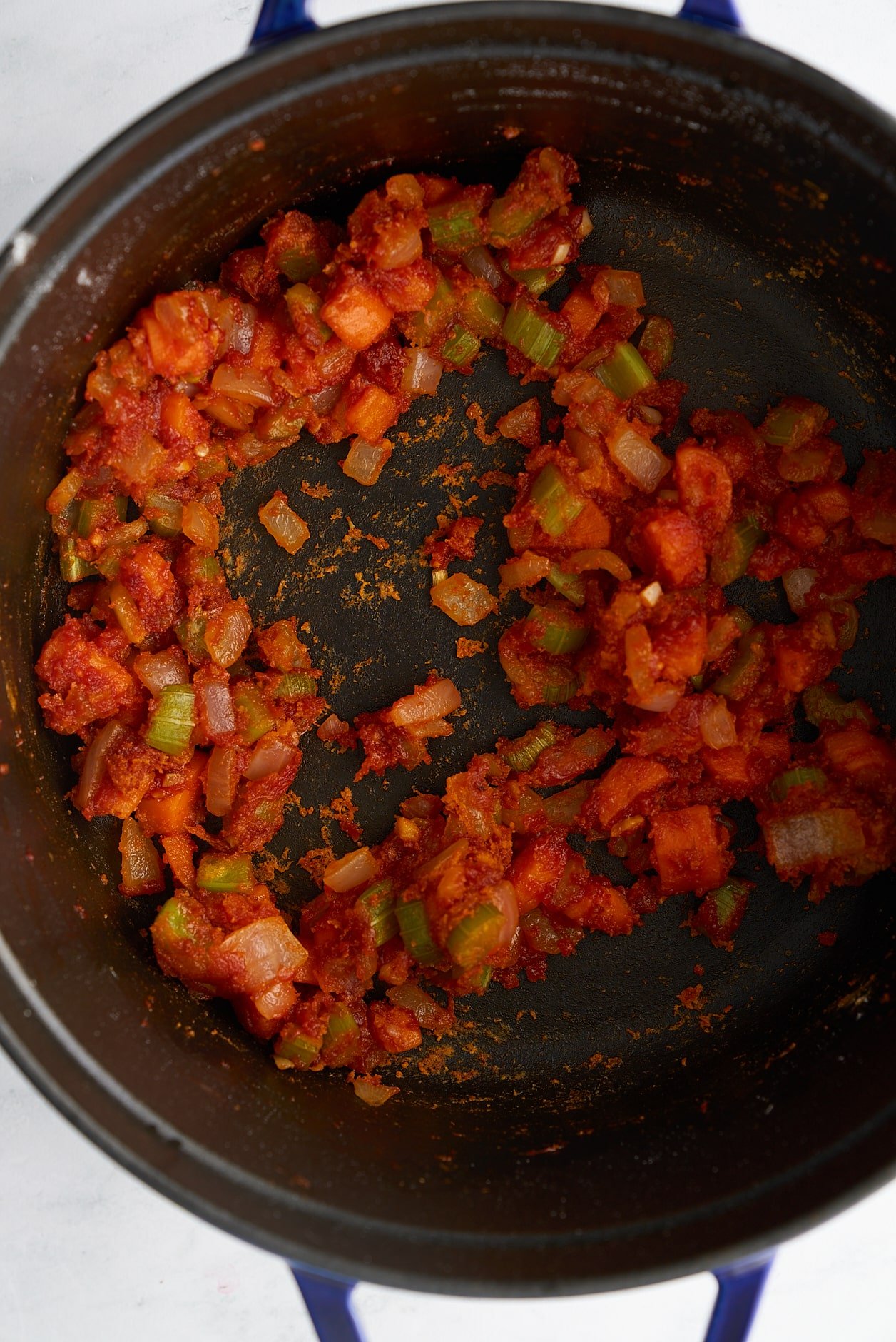 vegetables covered in tomato paste and flour cooking in pot