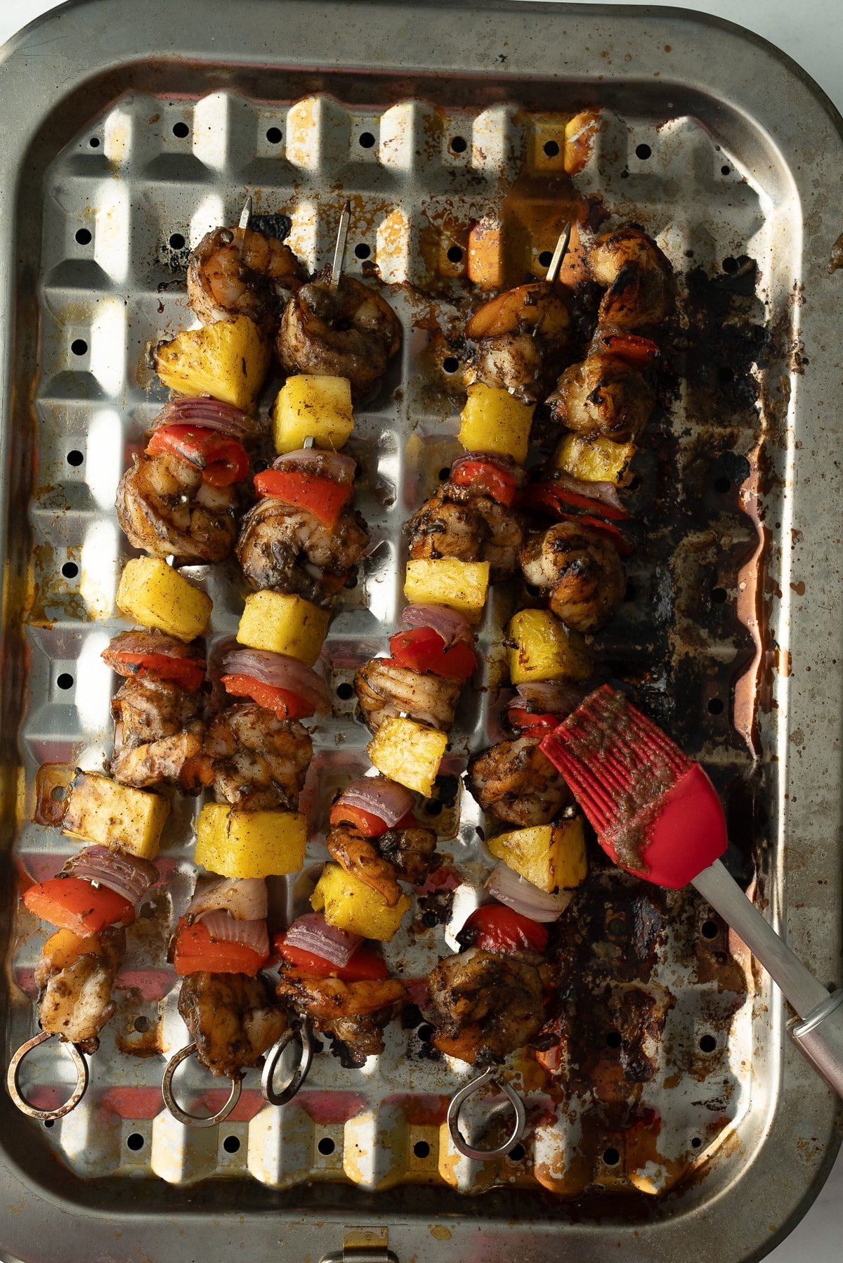 cooked jerk shrimp with glaze being rubbed on it