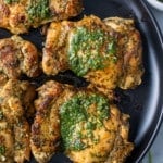 chimichurri chicken covered in the sauce on black plate
