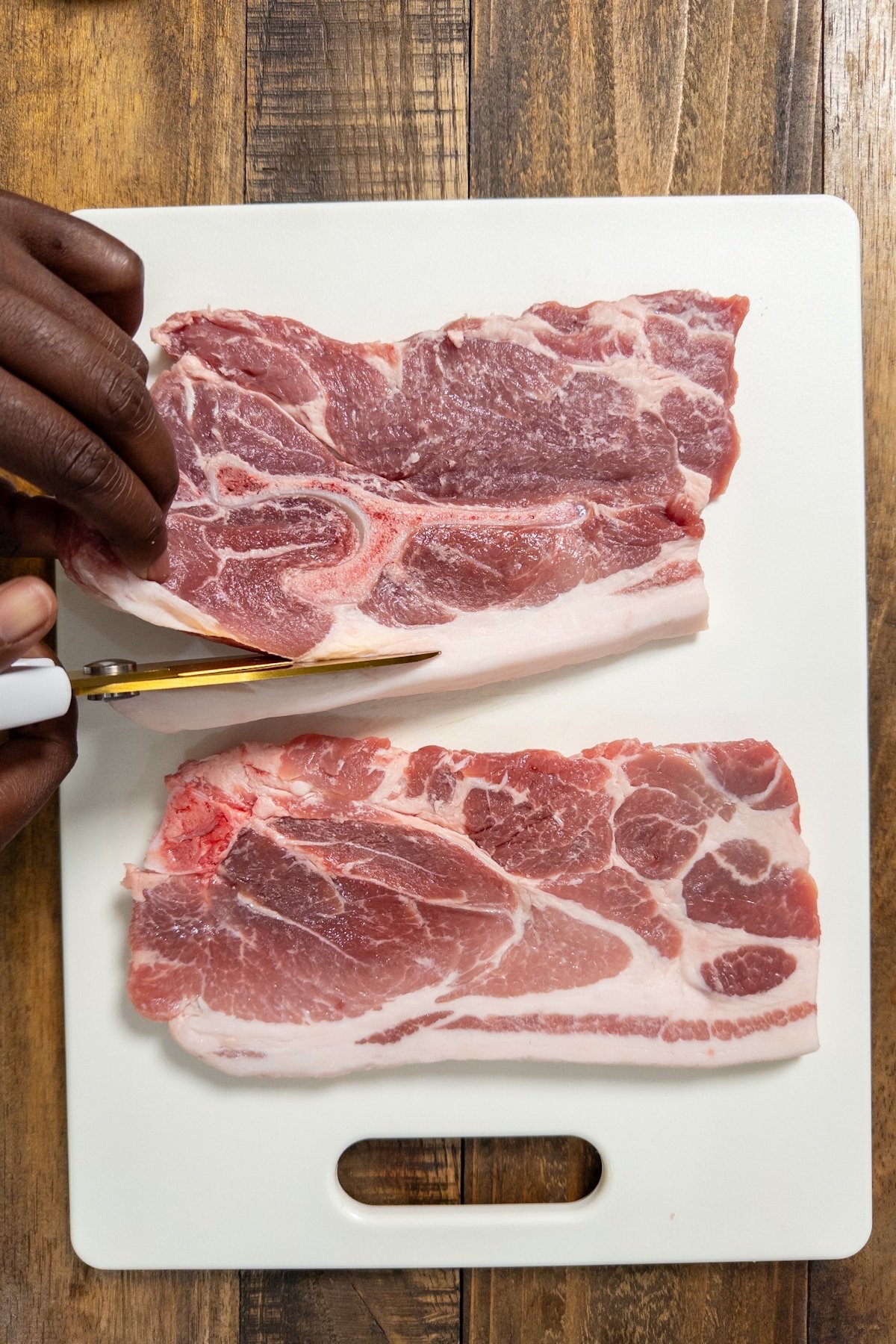 cutting excess fat on pork steak