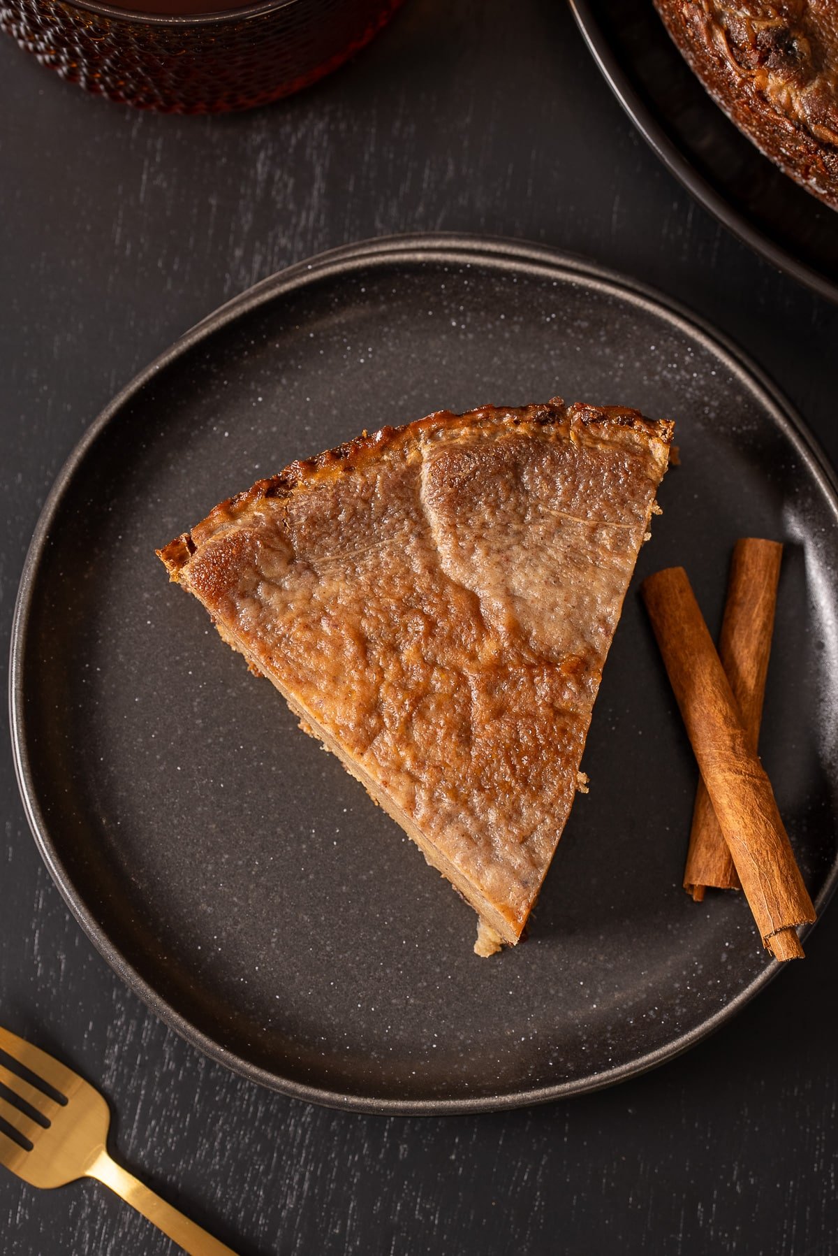 jamaican sweet potato pudding from above with cinnamon sticks on side