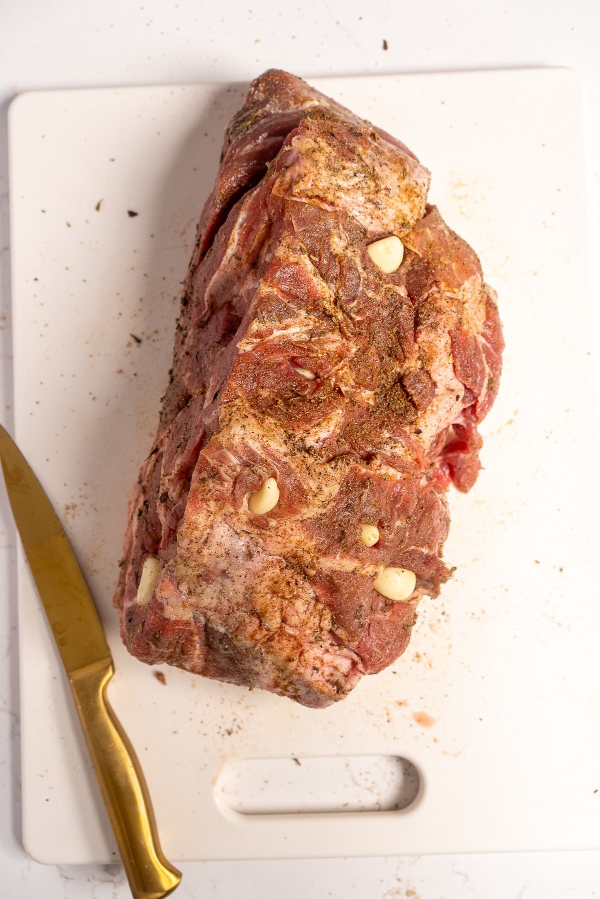 raw pork butt stuffed with garlic and seasoned with seasoning
