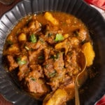 stovetop beef stew in black bowl with spoon in bowl