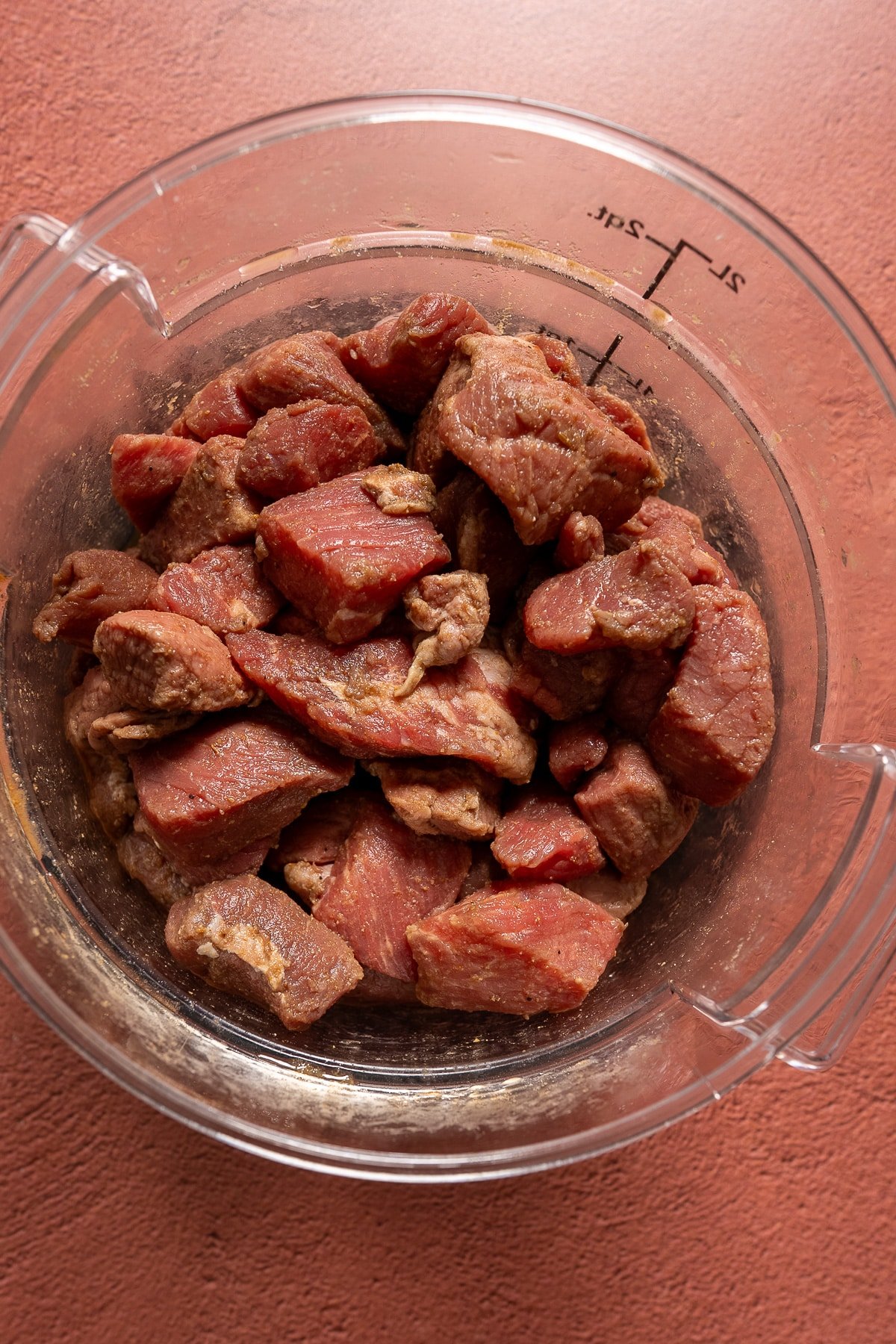 raw beef stew meat marinating in container