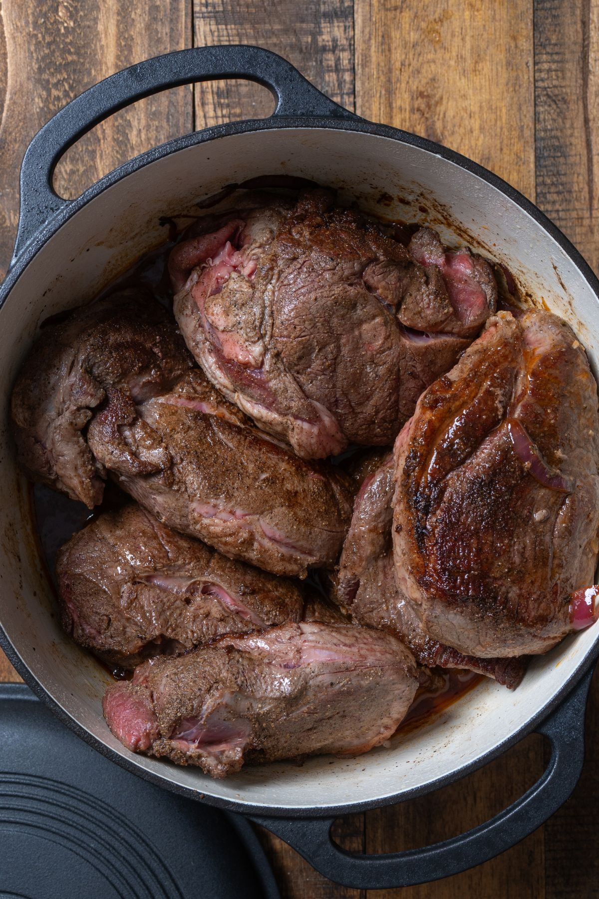lamb pieces in pot before braising