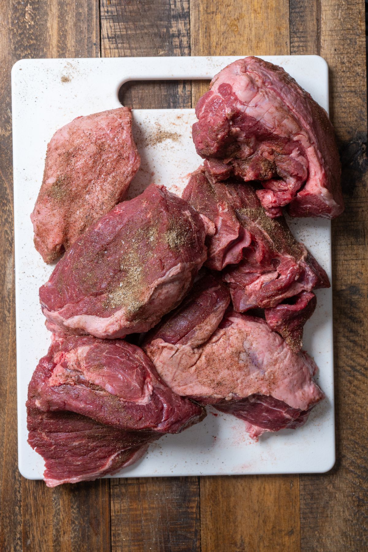 raw lamb leg cut into pieces and seasoned