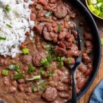 overhead of red beans and rice in black bowl with fork picking up beans