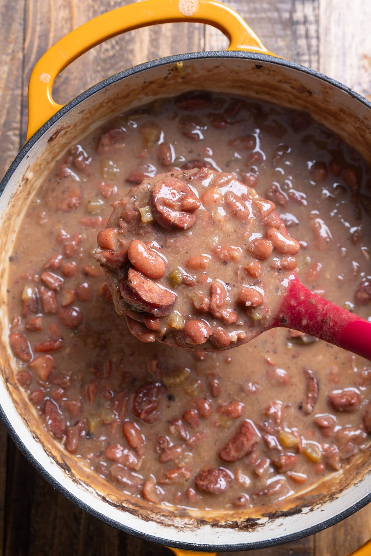spoon picking up creamy red beans and rice