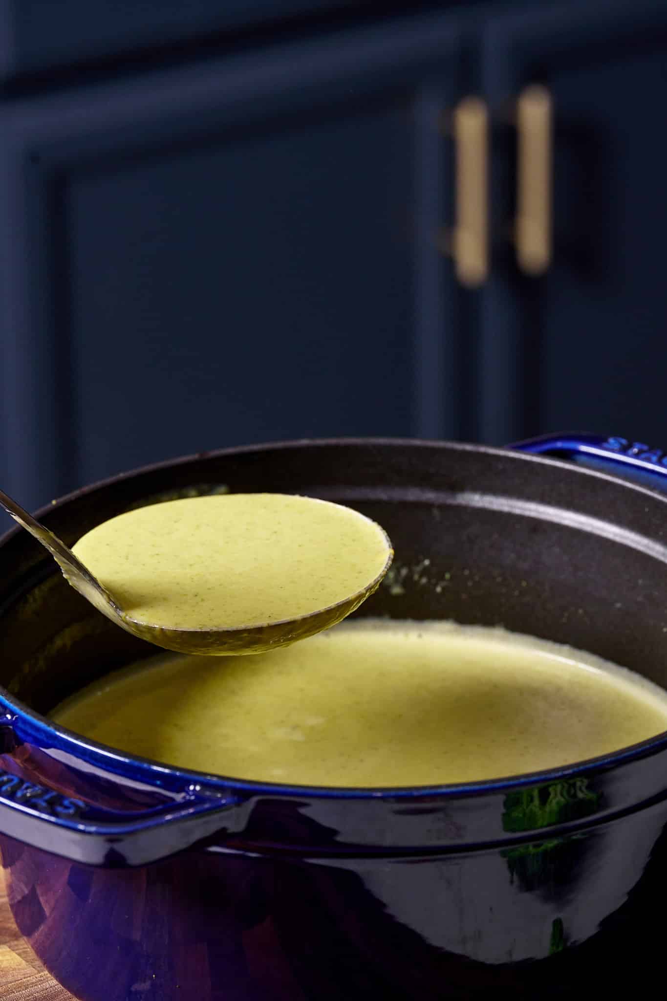 broccoli cheddar soup being picked up with spoon
