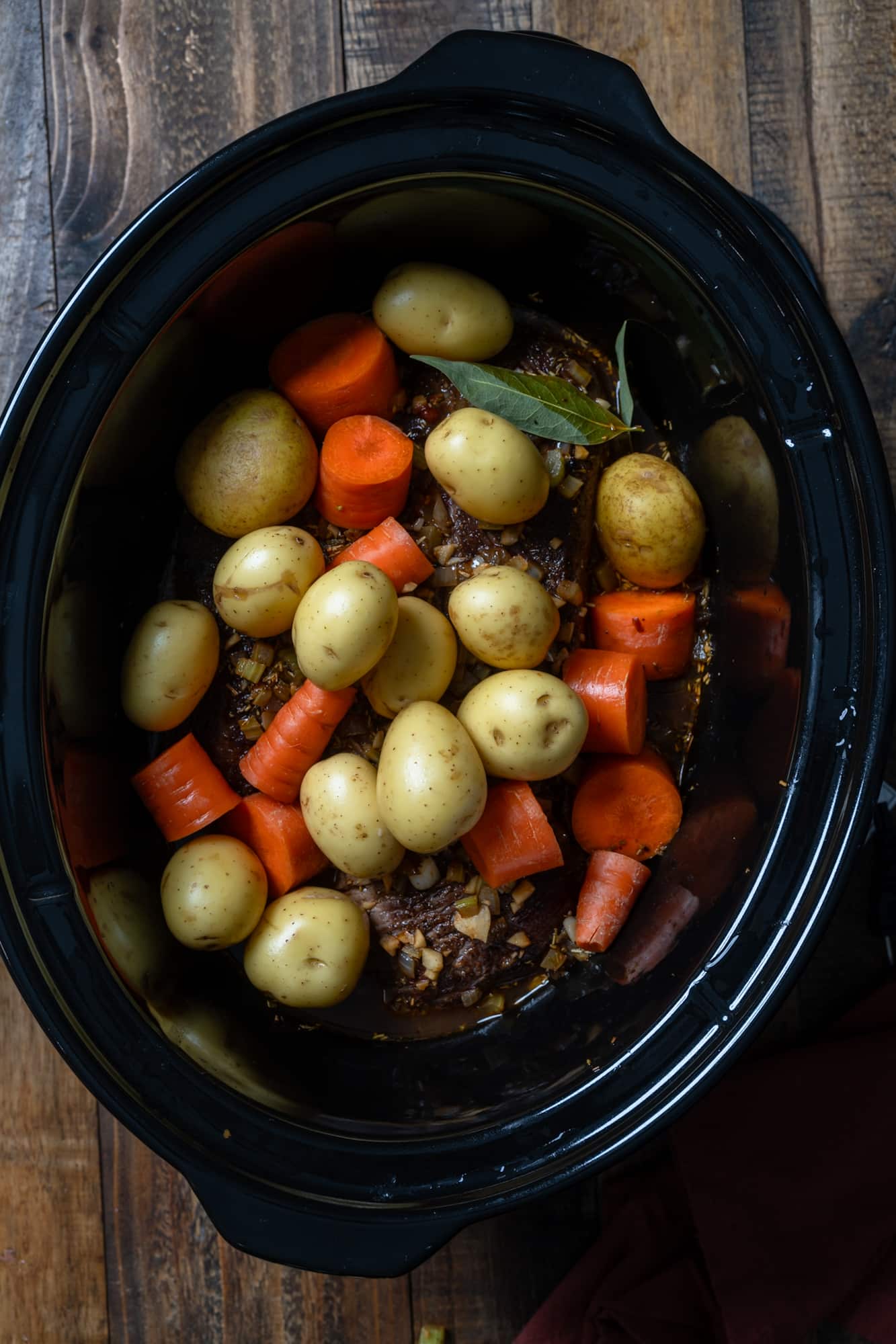 vegetables in slow cooker before cooking pot roast