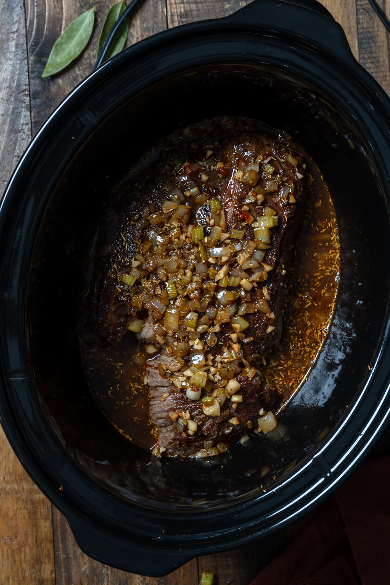 roast in slow cooker with ingredients poured over it