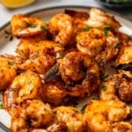 broiled shrimp on plate with lemon and pardley in background