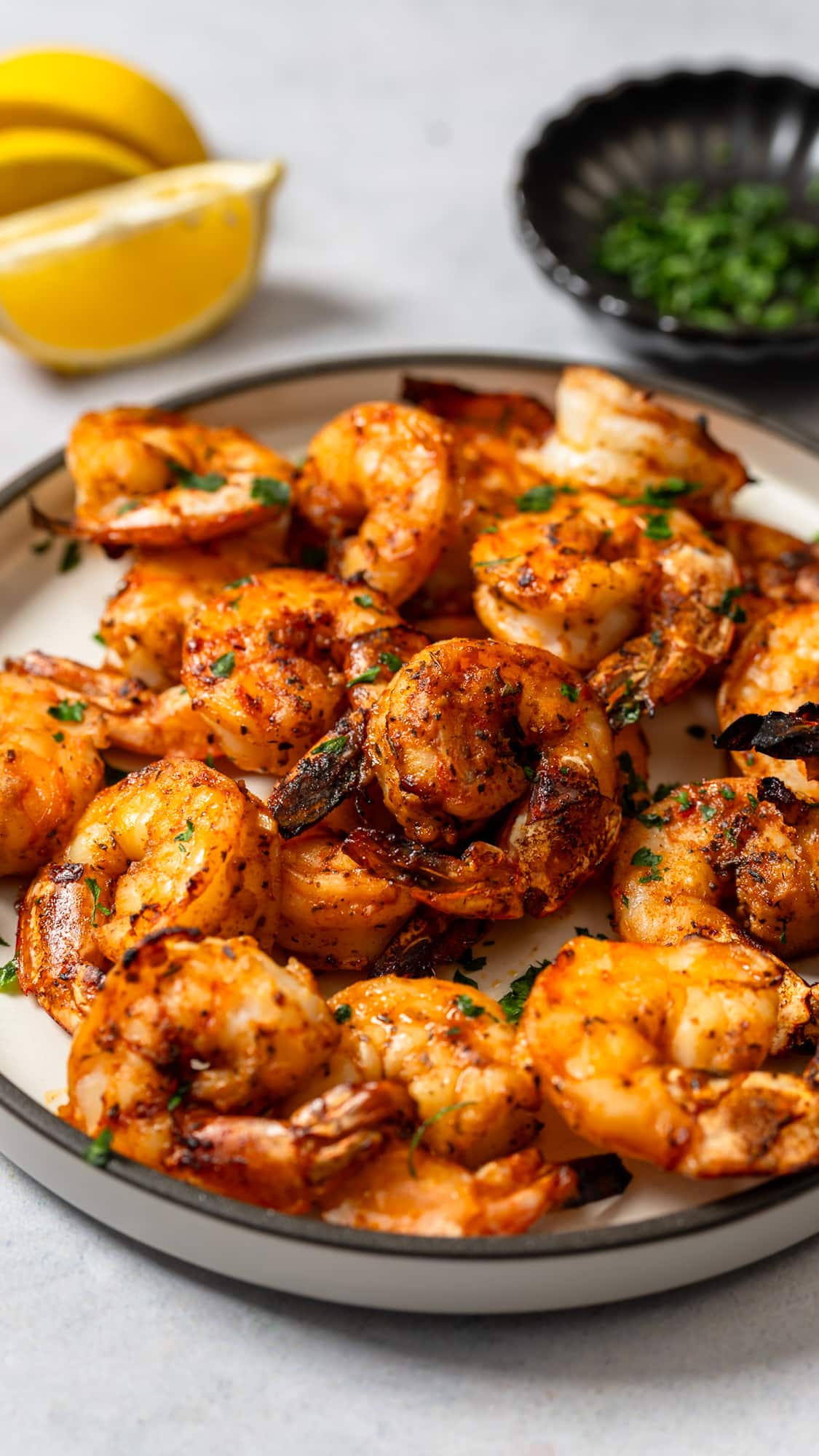 broiled shrimp on plate with lemon and pardley in background
