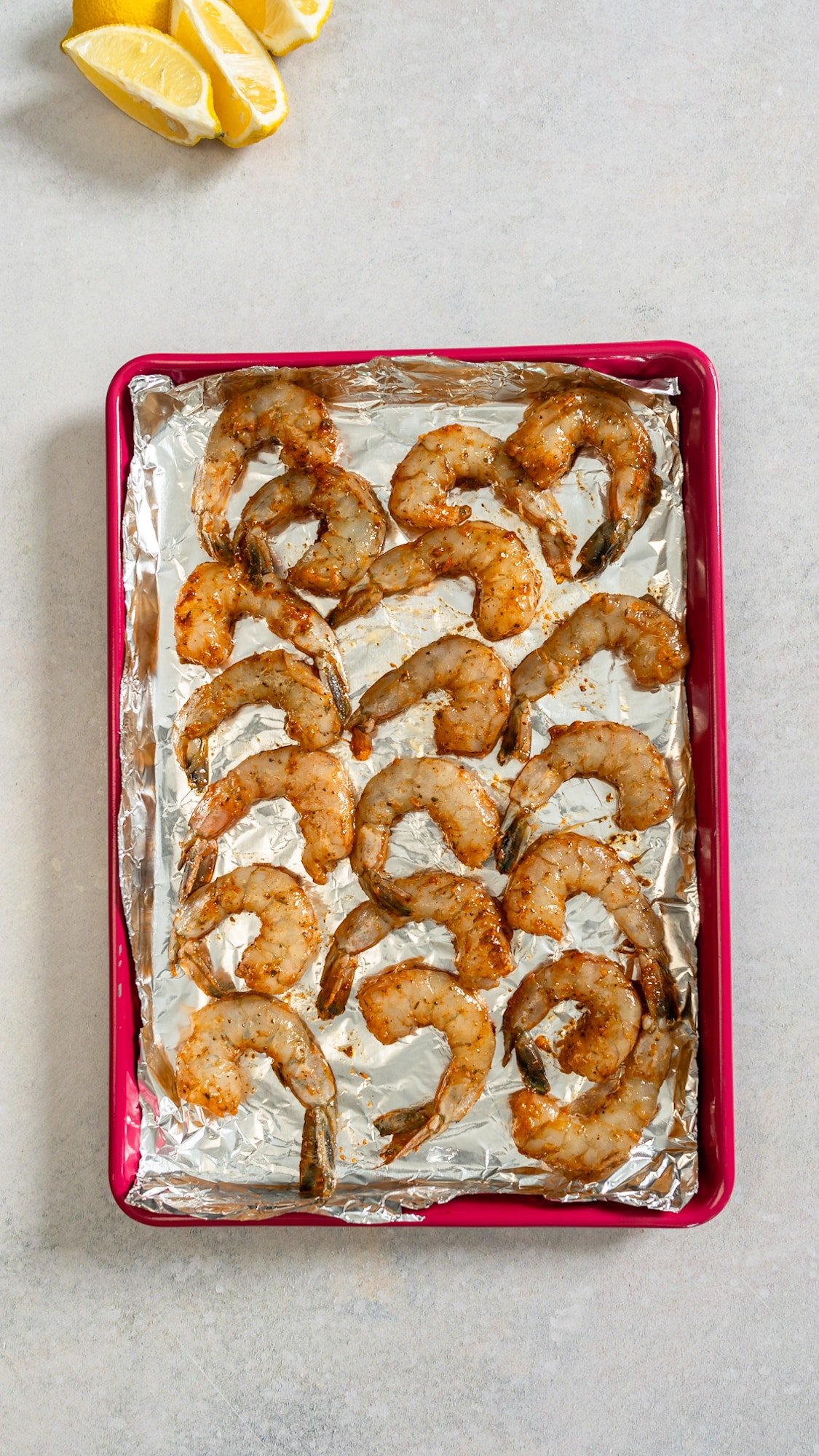 raw seasoned shrimp on baking sheet
