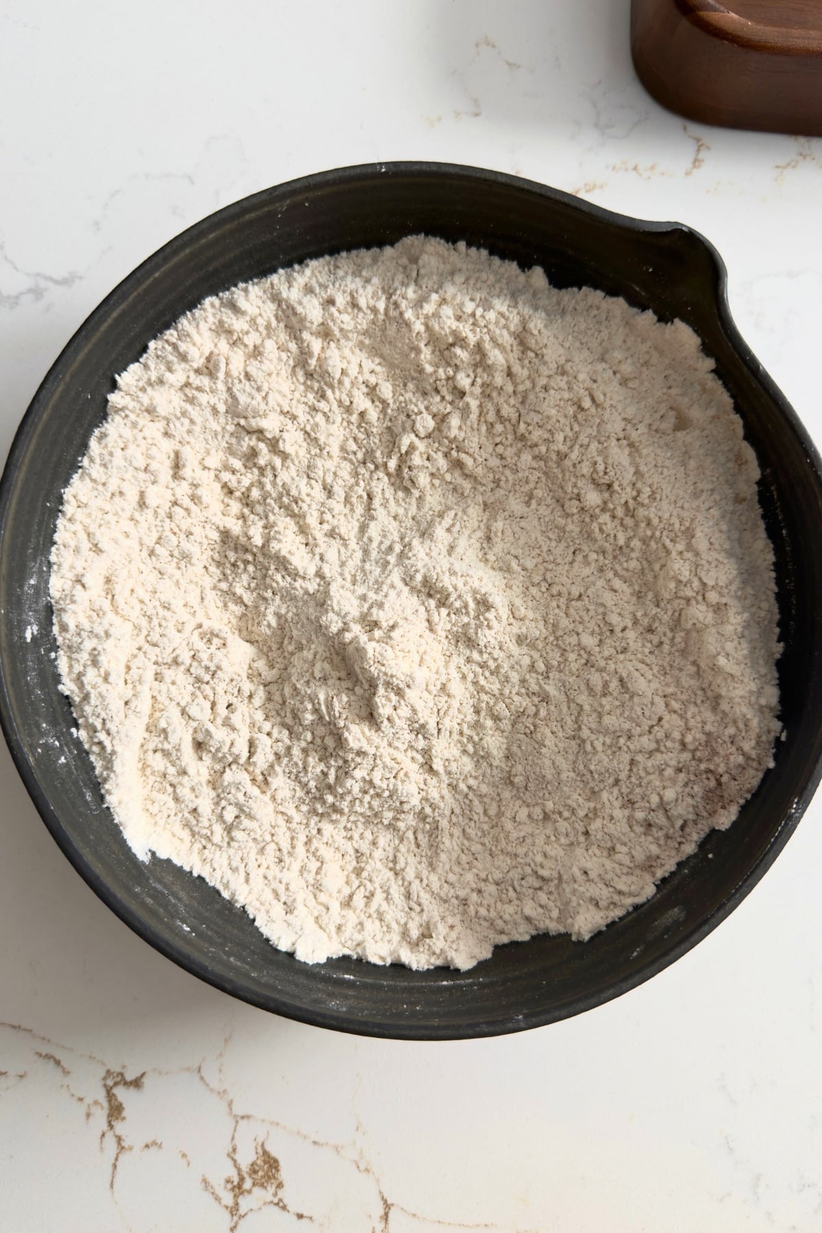 Flour and dry ingredients mixed in black bowl