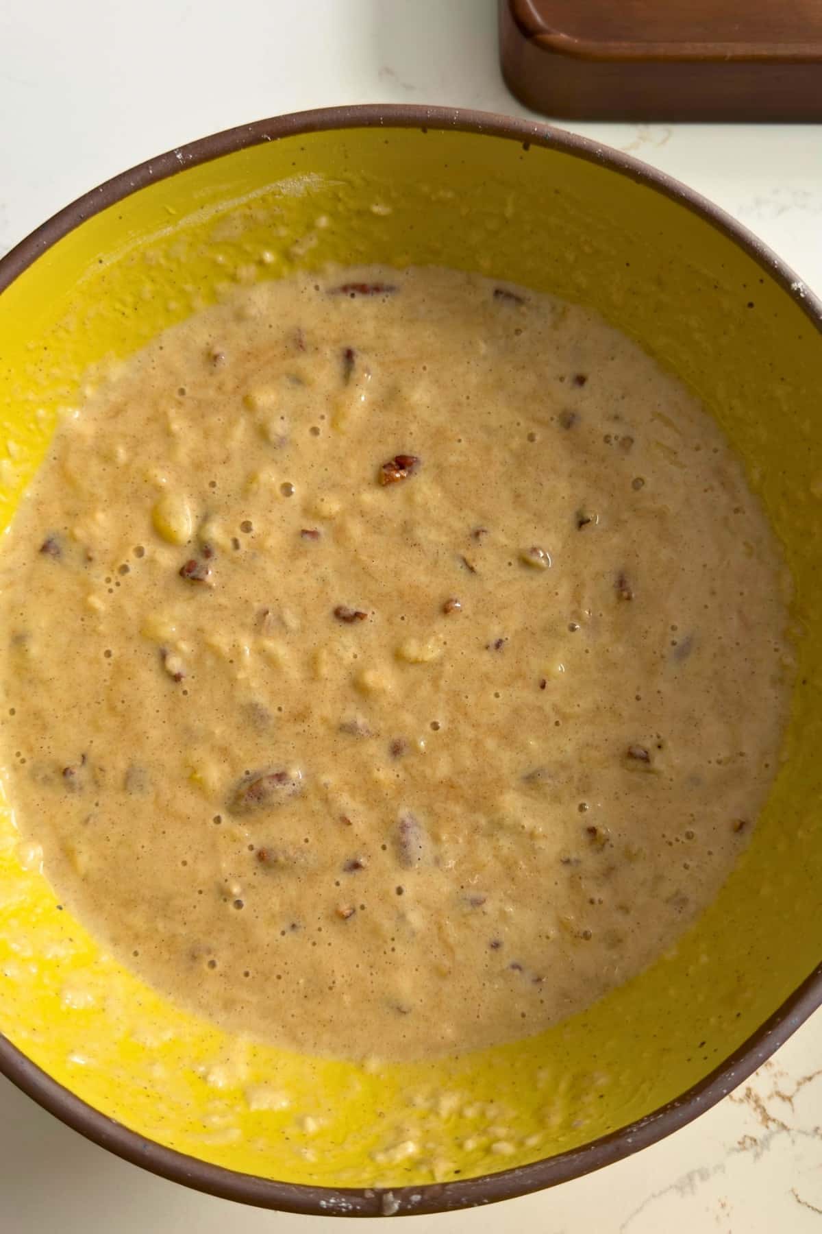 Wet batter for hummingbird cake and yellow bowls