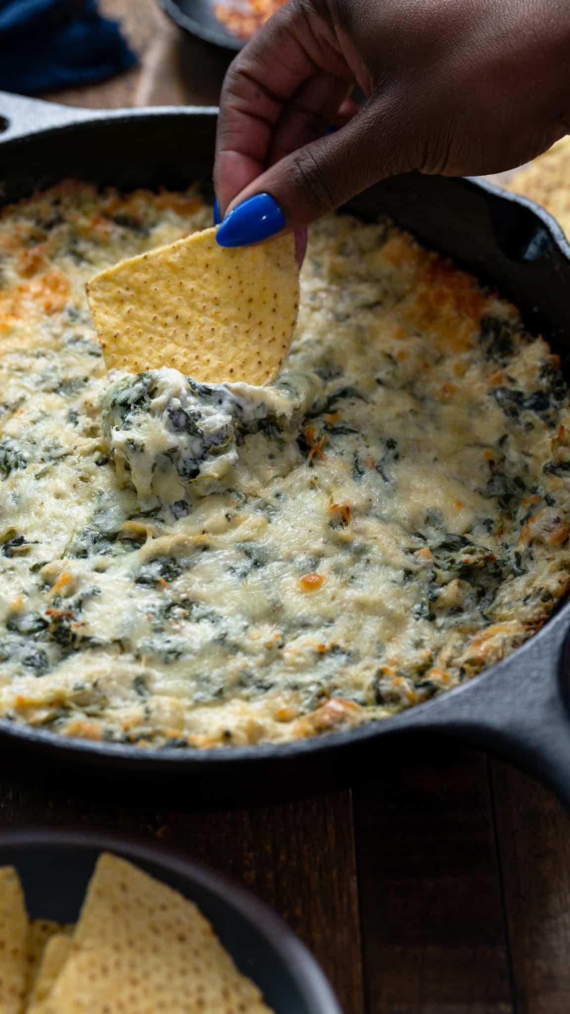 Chip picking up spinach artichoke dip