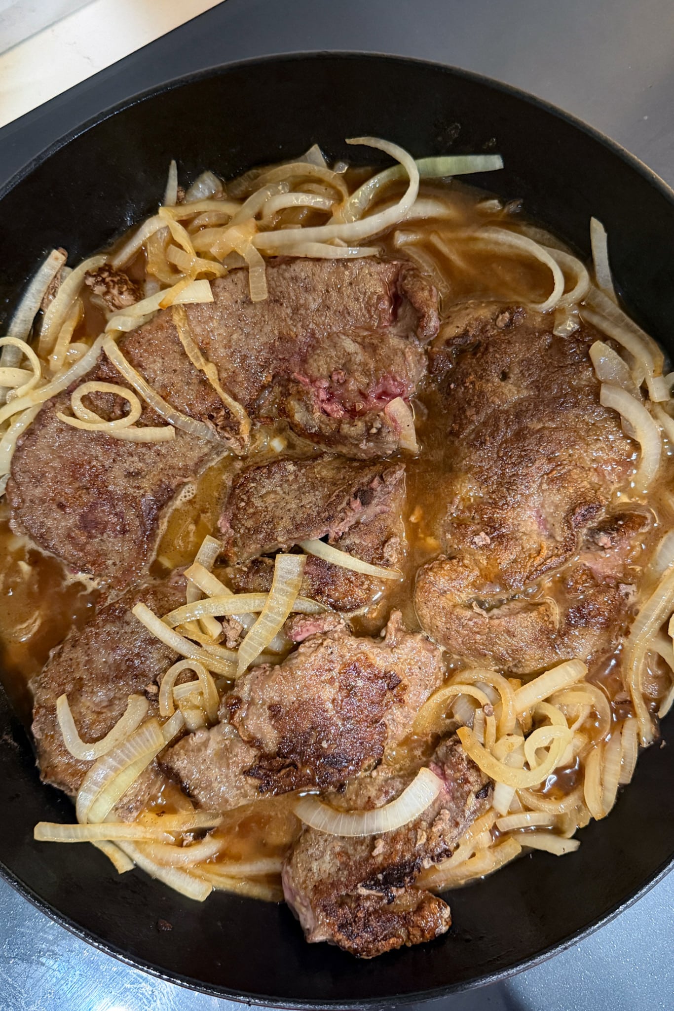 Liver and onions cooking in skillet