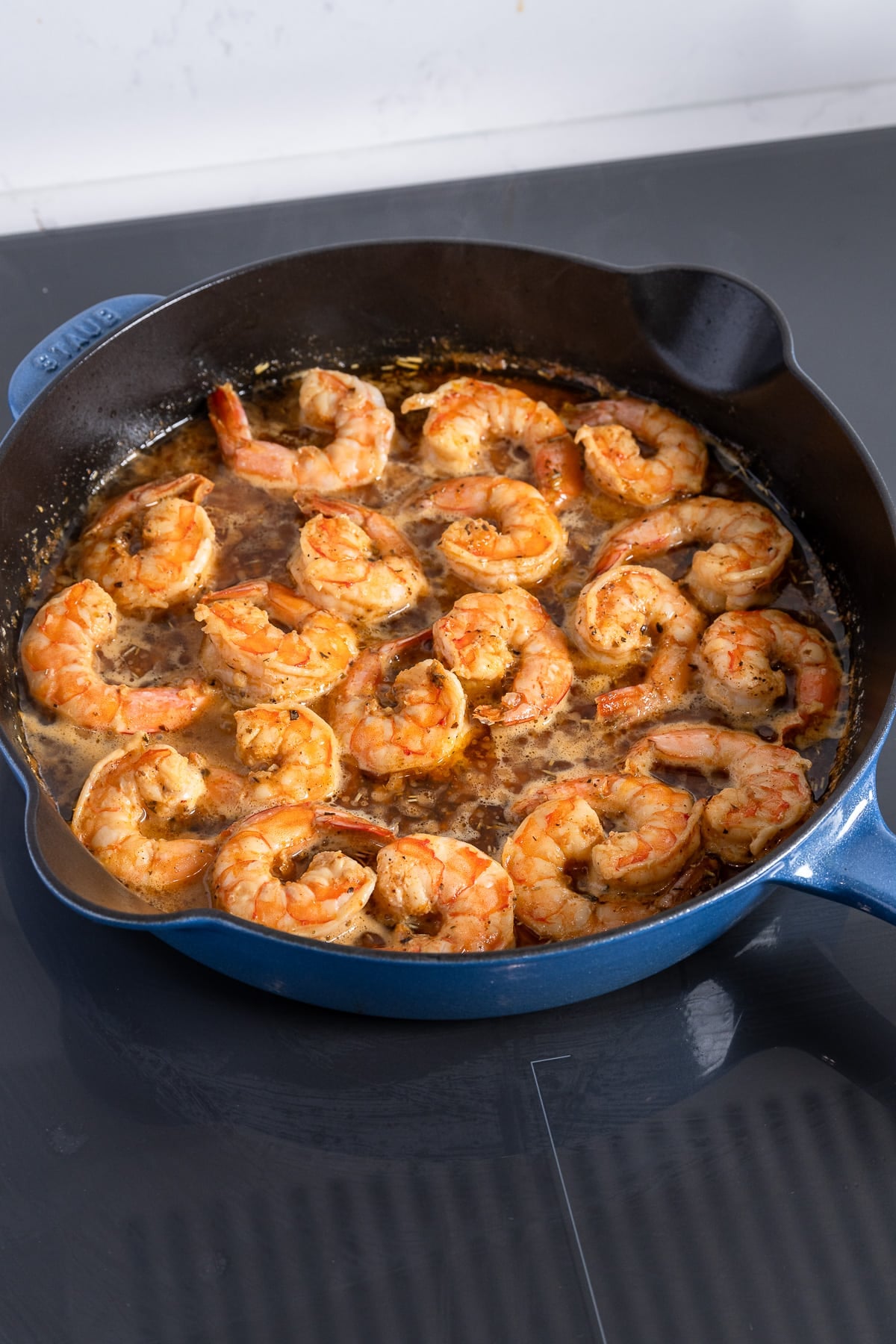Bbq shrimp in a skillet on the stovetop.